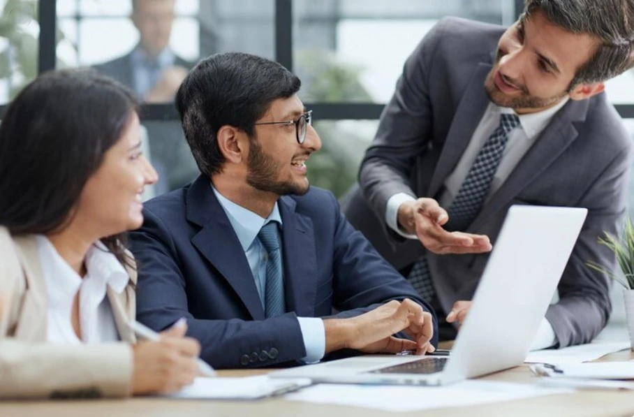 A diverse team of four professionals collaborating over a laptop at Nexa Business Solutions, the Best Digital Marketing Agency India, showcasing over 10 years of industry experience